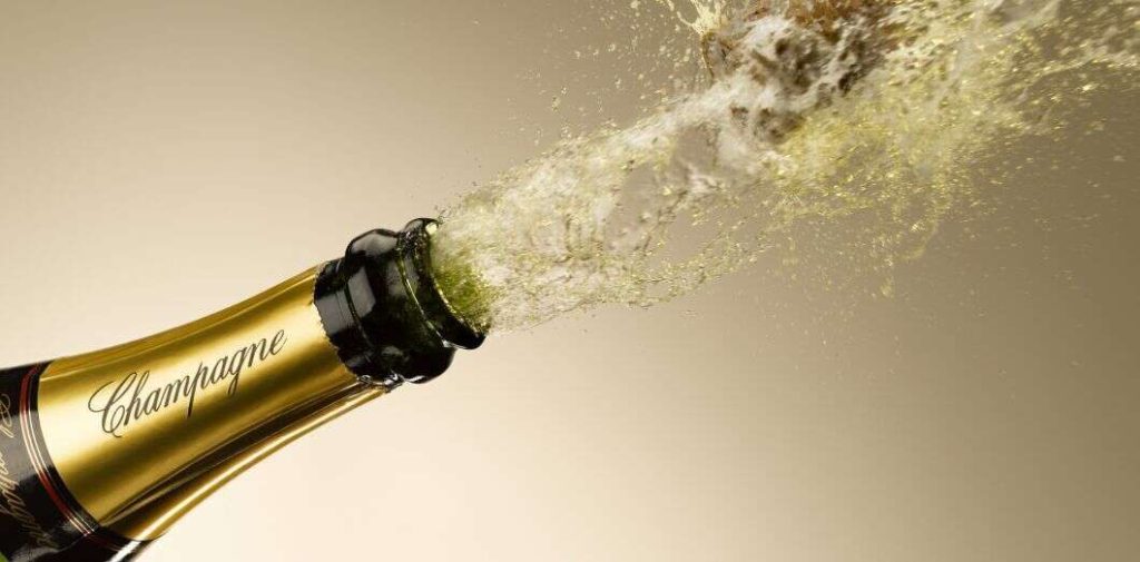 Bouteille de champagne ouverte illustrant la protection du nom patronymique face au droit des marques.